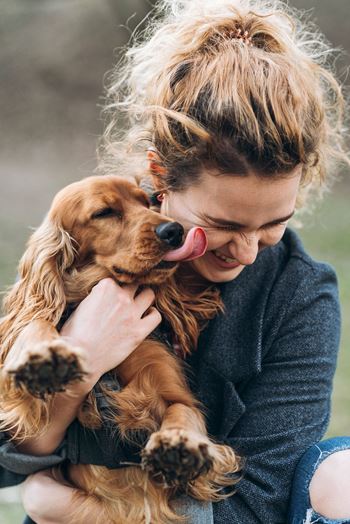 A woman holding a dog on her lap